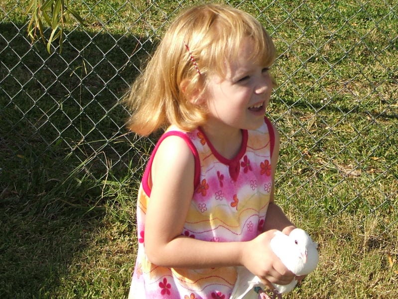 Child laughing while holding a white dove at a Doves 4 Yall event in North Texas