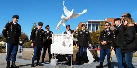 Military ceremony with dove monument